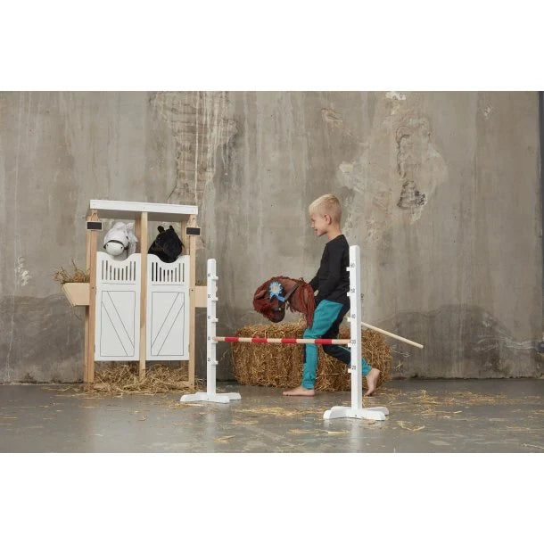 Kind springt über das Hobby Horse Hindernis